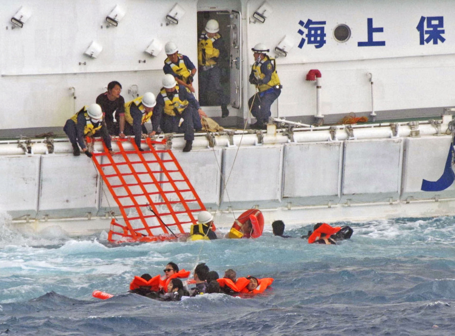 船から海に投げ出され、海上保安庁の巡視船に救助される人たち＝16日午後、沖縄県・下地島沖（第11管区海上保安本部提供）