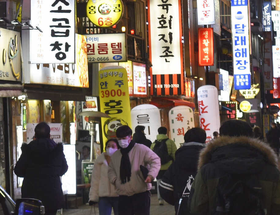 韓国・ソウル中心部の飲食店街を行き交う人たち＝1月（共同）