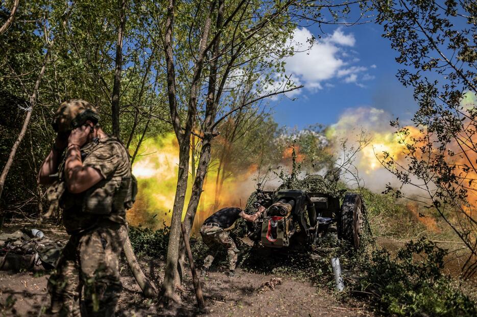 ウクライナ東部ドネツク州でロシア軍の陣地に向けてりゅう弾砲を発射するウクライナ兵＝13日（ゲッティ＝共同）