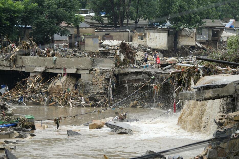 豪雨の影響で川の堤防が決壊した地区＝1日、北京（共同）