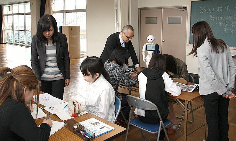 [写真]専門学校での授業の様子。ペッパーが見守るなか、生徒がグループに分かれディスカッション