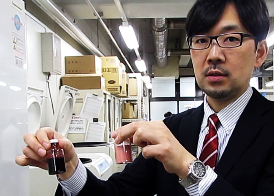 人工血液を手に持つ中央大学理工学部応用化学科の小松晃之教授