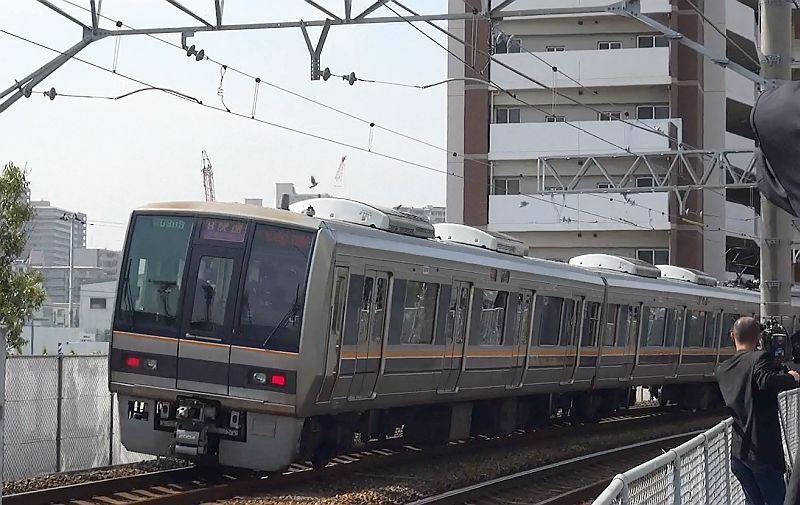 [写真]JR福知山線脱線事故の現場マンション付近では多くの人が手をあわせていた＝25日午前9時15分ごろ、兵庫県尼崎市で