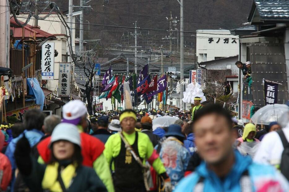 [写真]地区ごとののぼりを立てて市街地を曳行