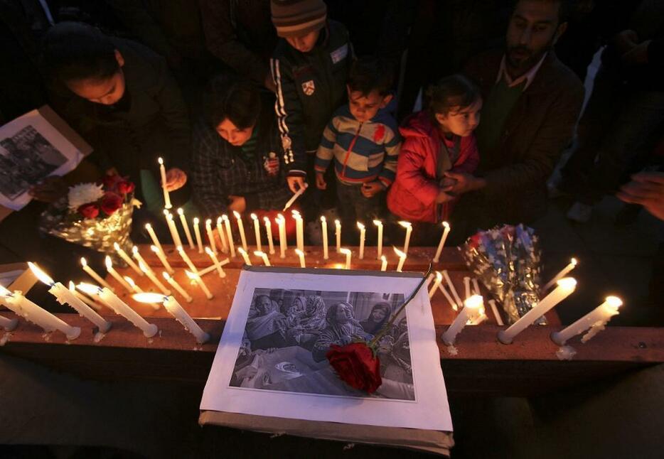 [写真]パキスタンの学校襲撃で犠牲になった生徒らの死を悼む市民ら（ロイター/アフロ）