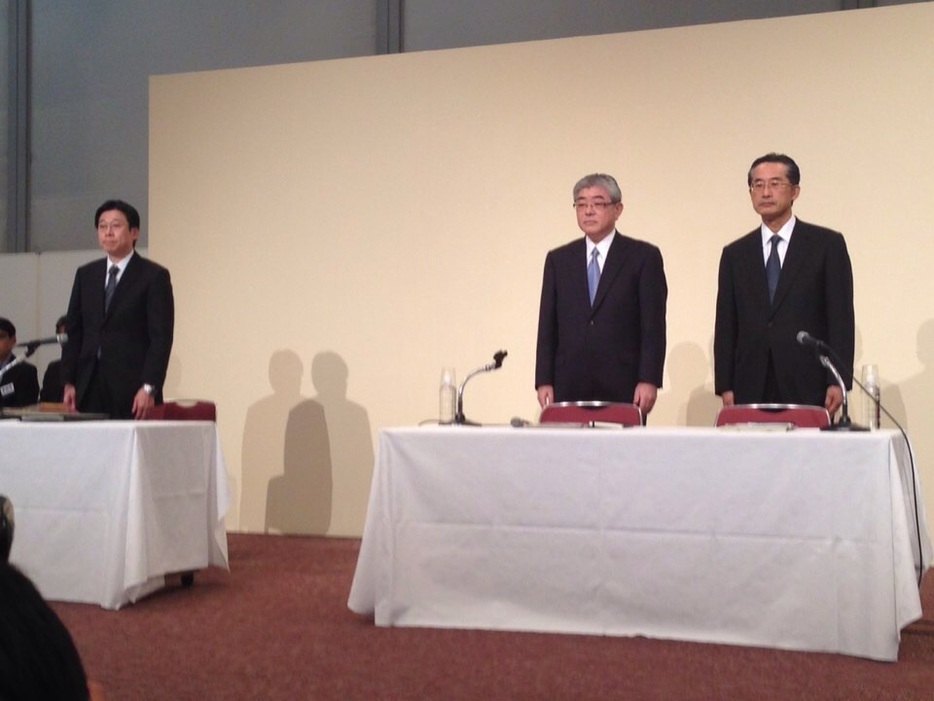 [写真]会見に出席した渡辺雅隆新社長（中央）と飯田真也新会長（右端）、高田覚取締役