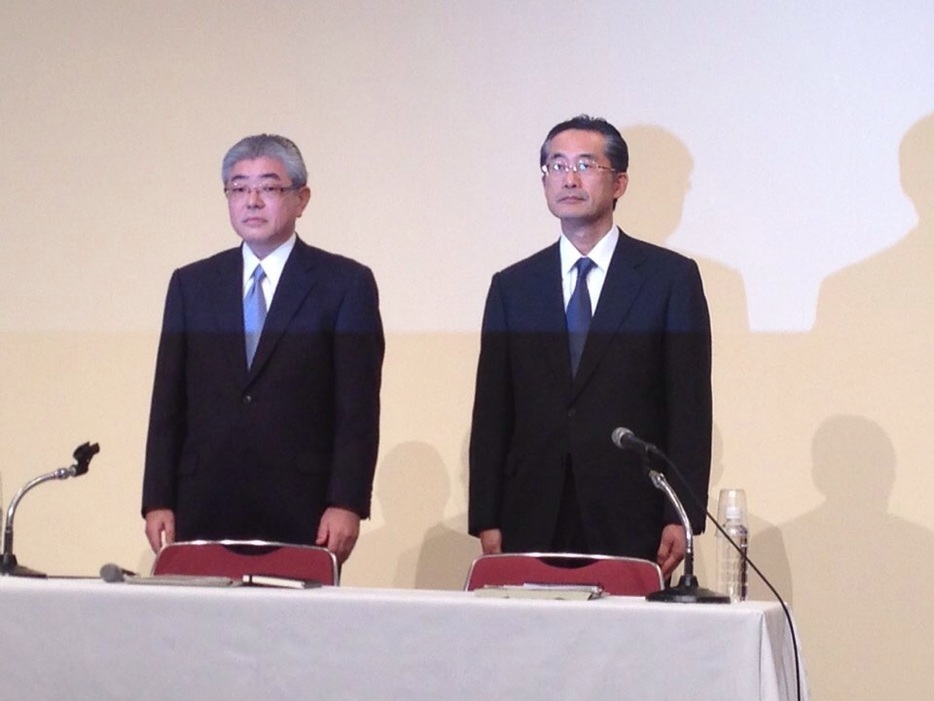 [写真]就任会見に臨む渡辺雅隆新社長（左）と飯田真也新会長