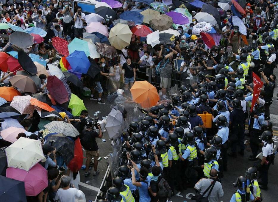 [写真]9月末から約2か月半にわたり行われた香港の民主化デモ。デモ隊は放水に雨傘で対抗した