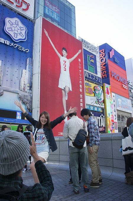 [写真]両手を大きく広げて綾瀬はるか看板と記念撮影。このような光景が多くみられる=大阪市中央区で