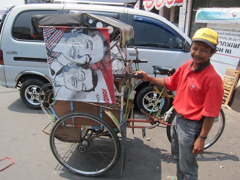 [写真]荷台にジョコウィの旗を掲げた運転手（河野嘉誠氏撮影）