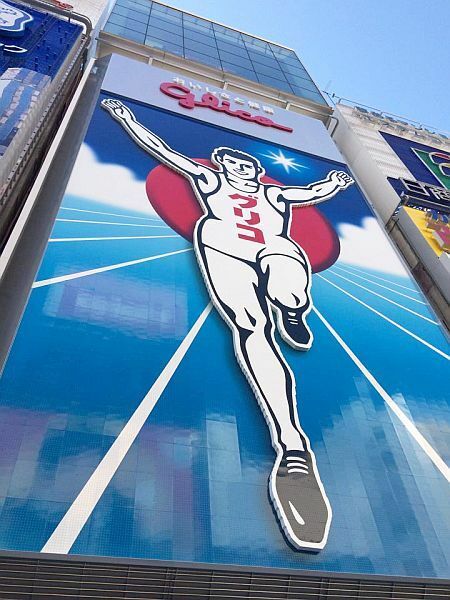 [写真]グリコ看板を真下から望む。よく見るとLEDのプツプツが確認できる＝24日午前9時半ごろ、大阪市中央区道頓堀で