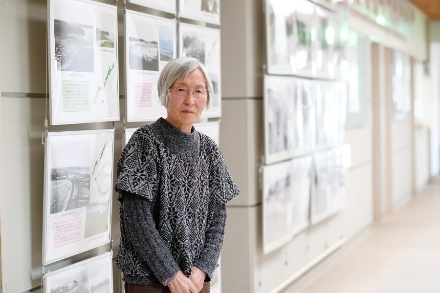 北方領土の写真が飾られた千島会館ロビーに立つ長谷川ヨイさん＝16年11月、撮影：山本宏樹/deltaphoto