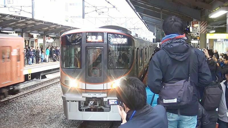 [写真]323系が京橋駅に到着。一気に車内は満員状態となった。反対ホームでも大勢の人が見守っていたが、現行のオレンジの車両も反対車線に到着した=24日午後4時10分ごろ、JR京橋駅ホームで