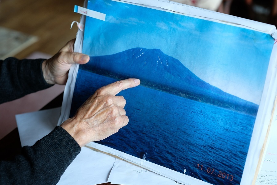 爺爺岳の写真を指差す佐藤さん＝16年11月、撮影：山本宏樹/deltaphoto