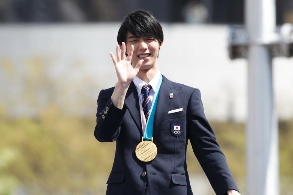 [写真] 沿道を埋めつくしたファンに手を振る羽生選手（写真：田村翔/アフロスポーツ）