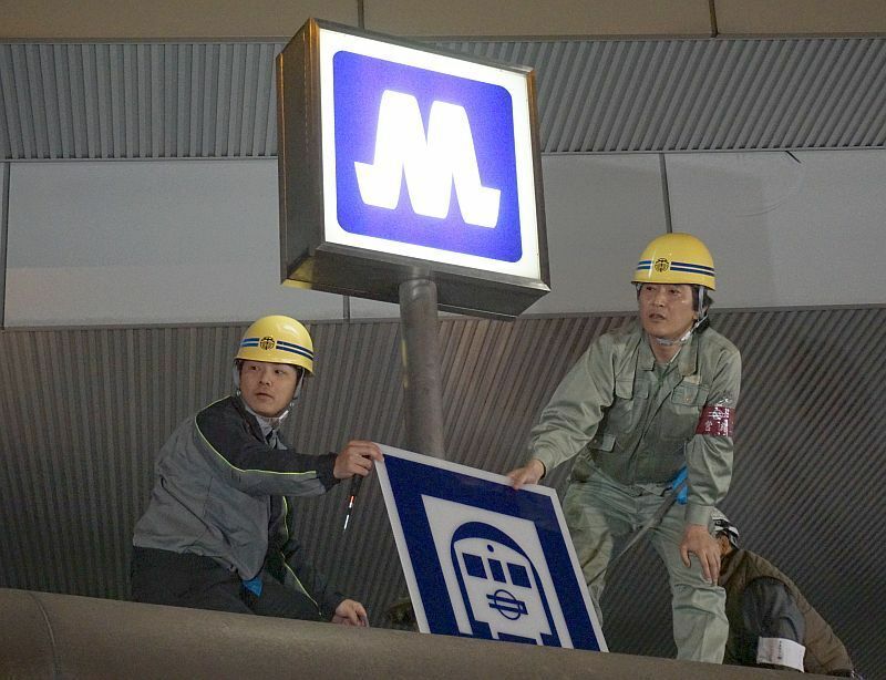 [写真]大阪市営地下鉄の看板をはずし、Osaka Metroの看板に変える職員＝1日午前2時半ごろ、大阪市北区の梅田駅で（撮影：柳曽文隆）