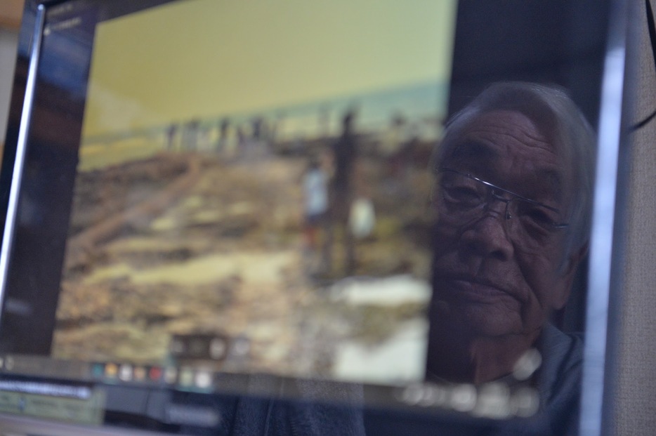 パソコンに保存した避難者らの写真を見る木村さん