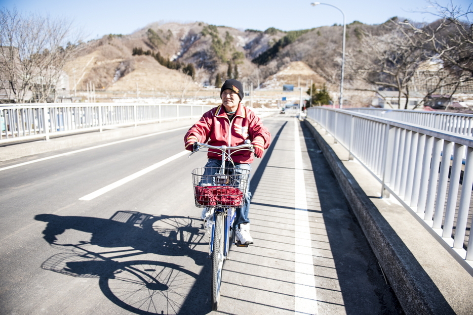 軽快に自転車に乗る姿は、村の風物詩　写真：佐藤慧