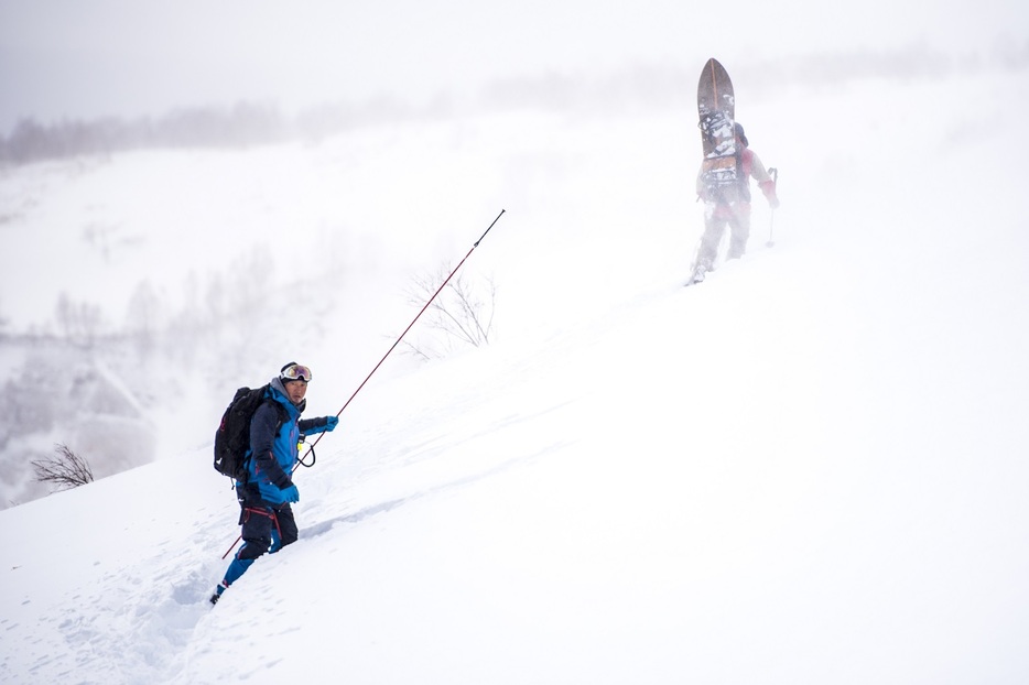 積雪の状況を調べる工藤さん　写真：佐藤慧