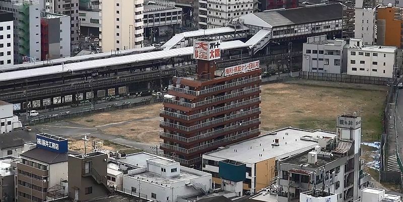 [写真]話題となっているJR新今宮駅前の土地。すぐ隣には「日払い可」のアパートもある＝大阪市浪速区で（撮影：柳曽文隆、協力：通天閣観光）