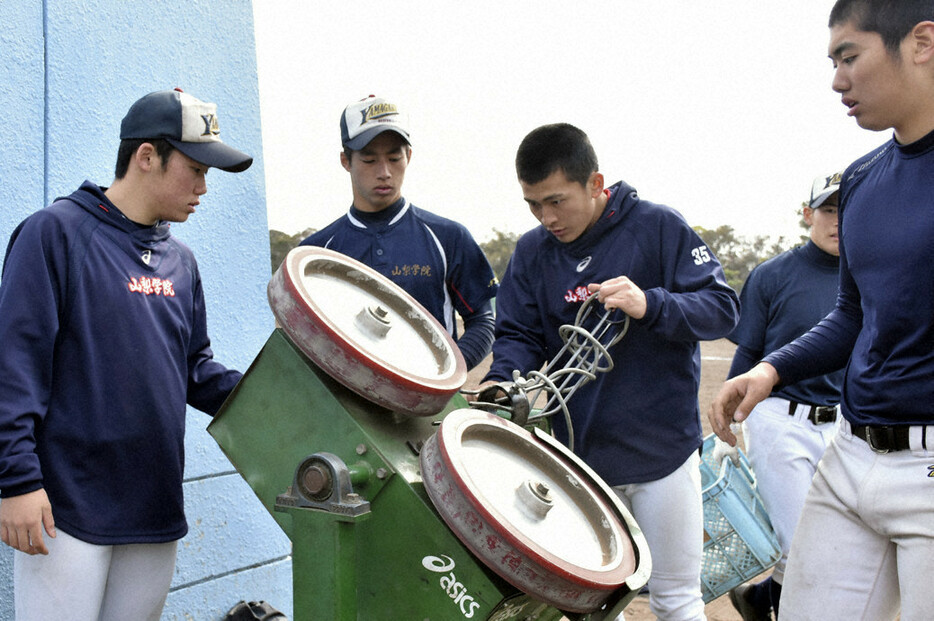 ピッチングマシンを片付ける「サポーター」の選手たち＝兵庫県伊丹市で、金子昇太撮影