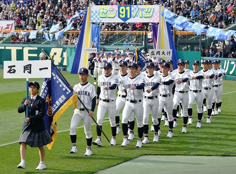 堂々と入場行進する石岡一の選手たち＝阪神甲子園球場で、猪飼健史撮影