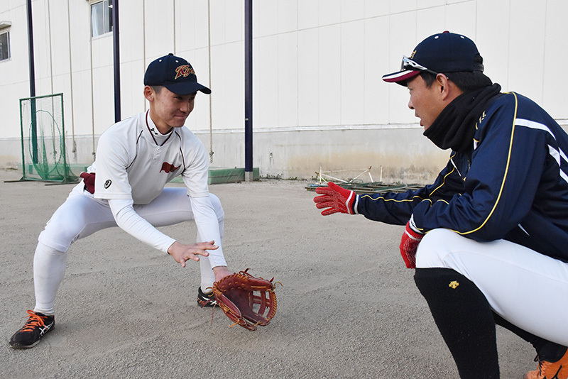 増田剛守備コーチ（右）から捕球姿勢について指導を受ける春日部共栄の丸田輝遊撃手＝埼玉県春日部市の同校で、畠山嵩撮影