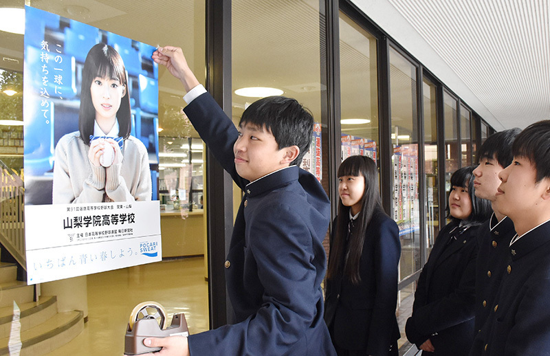 山梨学院の校内にポスターを張る生徒たち＝甲府市で、金子昇太撮影