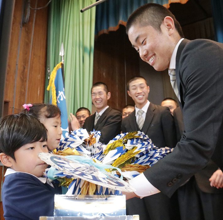 幼稚園児から千羽鶴を受け取る表主将＝大分県別府市野口原の明豊高校で、田畠広景撮影