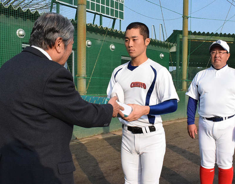 毎日新聞南福連合会の上野副会長（左）からボールを受け取る筑陽学園の江原主将＝福岡県筑前町で、宗岡敬介撮影