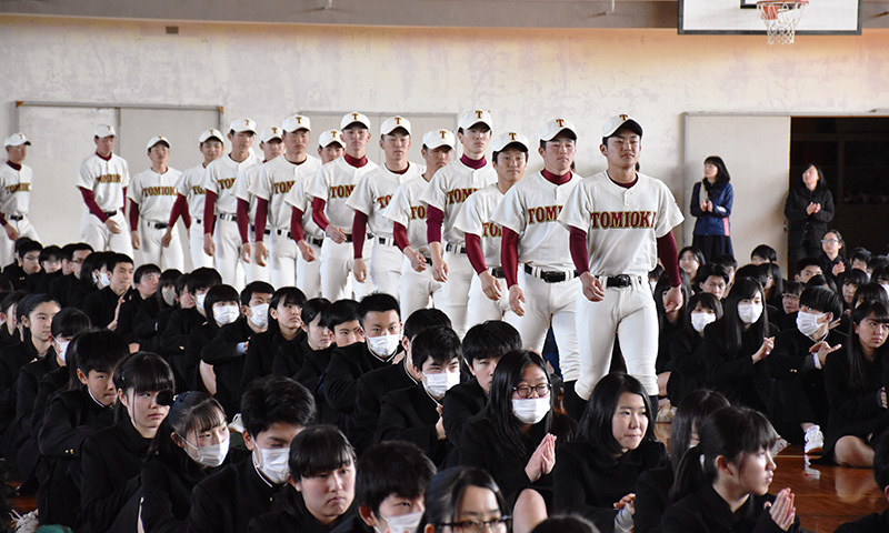 生徒たちに拍手で迎えられる中、堂々と入場する富岡西の選手たち＝徳島県阿南市富岡町小山の同校で、岩本桜撮影