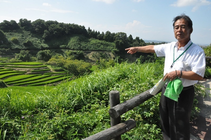 [写真]下赤阪の棚田を紹介する地元農家の千福清英さん