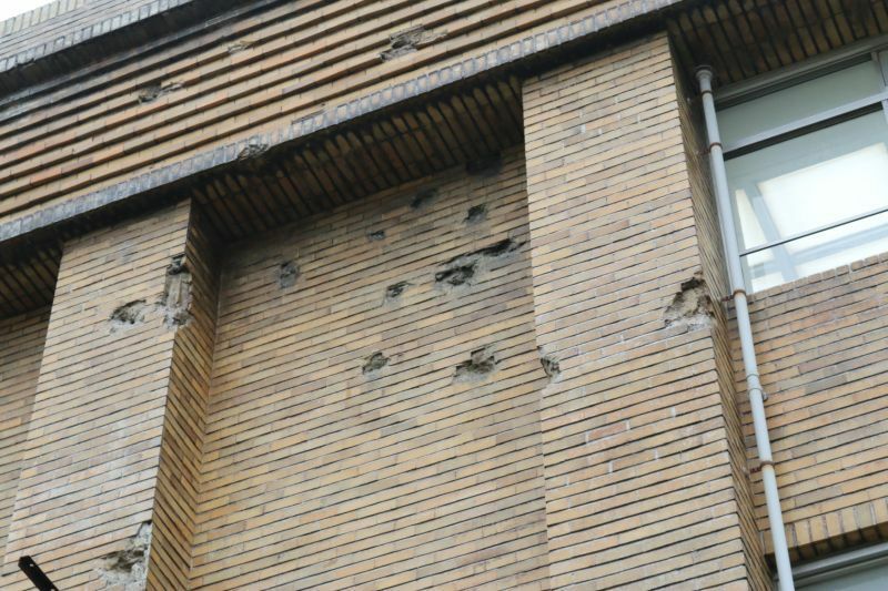 [写真]保存されている旧校舎の壁。機銃掃射痕が空襲の恐ろしさを物語る=大阪府立北野高校で（撮影：柳曽文隆）