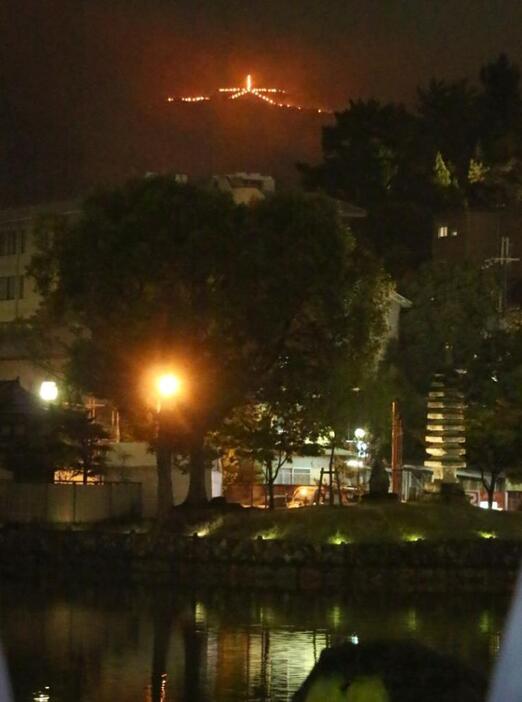 [写真]雨の中、高円山に「大」の文字が浮かび上がった=15日午後8時5分ごろ、奈良市の猿沢池から（撮影：柳曽文隆）