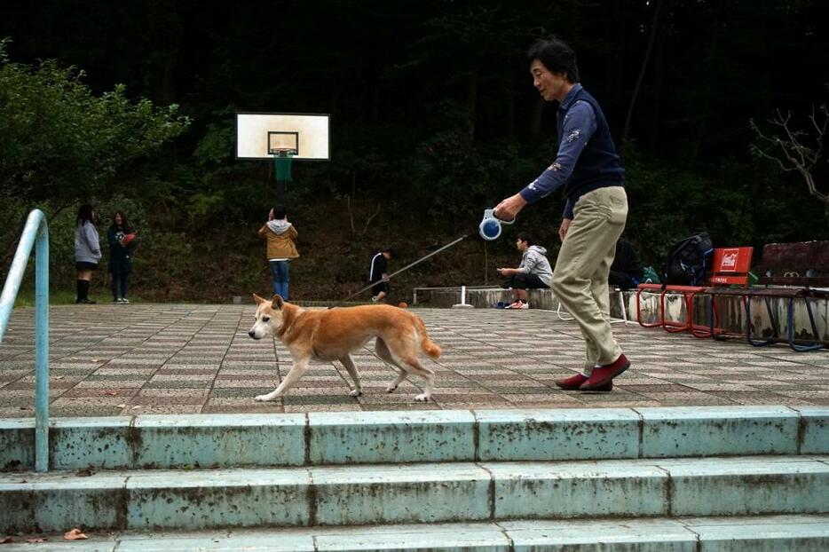 [写真]キャンパス内を散歩する絵里奈と江崎さん。生徒たちにとっても日常の光景だ