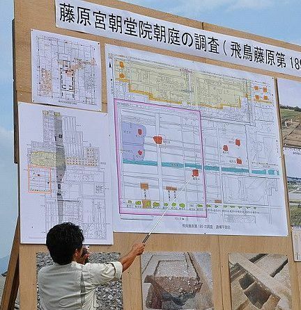 [写真]研究員が示す赤いポイントが7基の大型柱穴群のうち、中央の柱穴。東西に3基ずつ柱穴が並んで出土し、7本の旗が東西対照で立てられていた様子が分かった