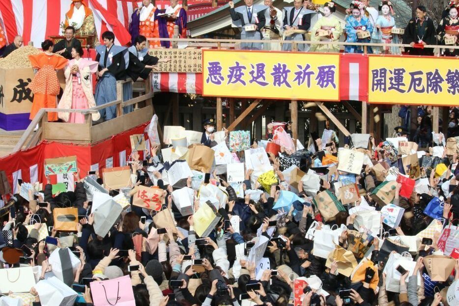 [写真]紙袋を広げ豆をもらおうとする人も多かった＝3日午前11時すぎ、大阪府寝屋川市で