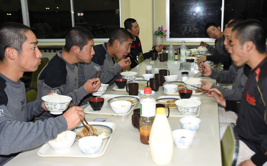 寮で食事をとる選手たち