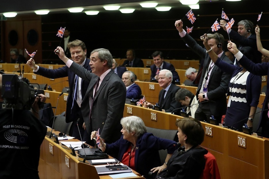 [写真]英国のEU離脱協定案が承認された欧州議会で英国国旗を振るブレグジット党のファラージ議員ら（ロイター/アフロ）