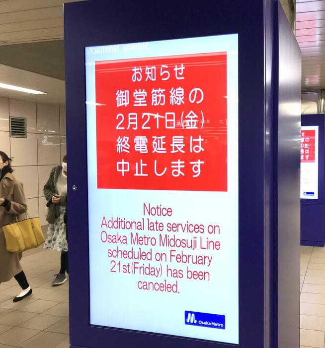 ［写真］駅のデジタルサイネージでも終電延長実験の中止が伝えられていた＝20日午後8時半ごろ、大阪市北区で