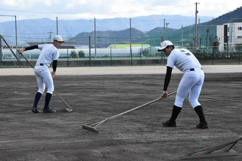 声を掛けながらグラウンド整備に取り組む１年生たち＝善通寺市の尽誠学園グラウンドで、喜田奈那撮影