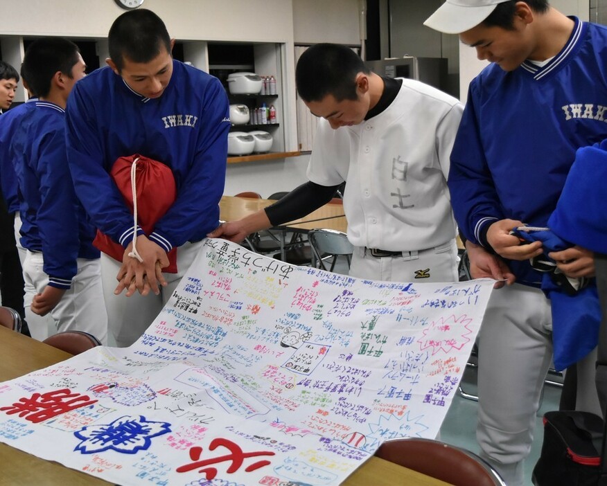 子どもたちからもらった寄せ書きを読む磐城の選手たち＝福島県いわき市平の磐城高校で