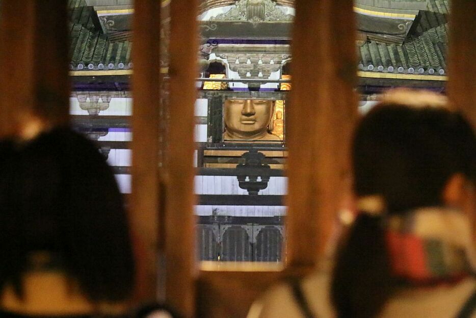 [写真]]東大寺・大仏殿の「観相窓」開扉は外から見られ、手を合わせる人の姿もあった＝10日午後7時すぎ、奈良市の東大寺で