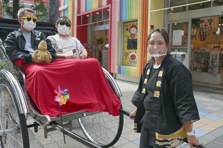 ［写真］通天閣前でガイドを行う板倉さん＝大阪市浪速区で