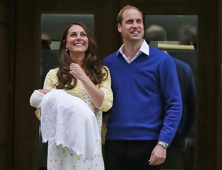 黄色のワンピース姿で、セントメアリー病院を退院するキャサリン妃とウィリアム王子＝2015年5月2日（写真：ロイター/アフロ）