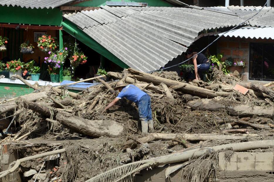 がれきを片付ける男性＝2015年5月18日（写真：ロイター/アフロ）