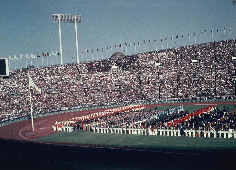 [写真]快晴の下で行われた東京五輪の開会式。93の国や地域が参加し、当時としては最大規模の大会だった（山田真市/アフロ）