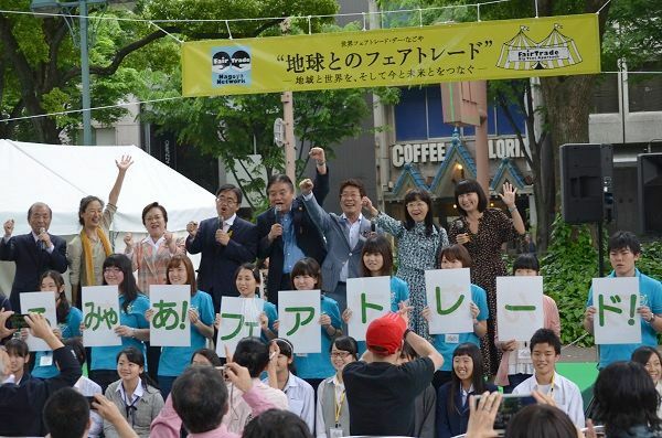 [写真]スローガンをコールする河村たかし名古屋市長、大村秀章愛知県知事らとスローガンの文字を持つ大学生