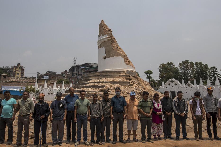 倒壊した世界遺産・ダラハラタワーの前で黙祷する人々＝2015年5月7日（写真：ロイター/アフロ）