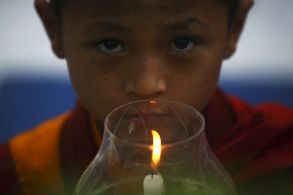 地震が止むように、祈る少年=2015年5月20日（写真：ロイター/アフロ）